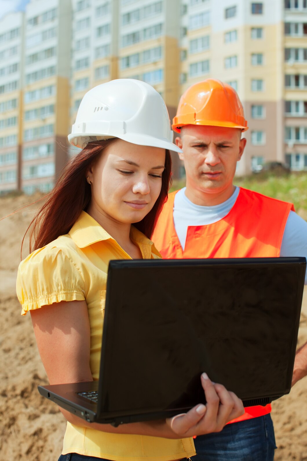 Construction builders wearing hardhats on a development site.