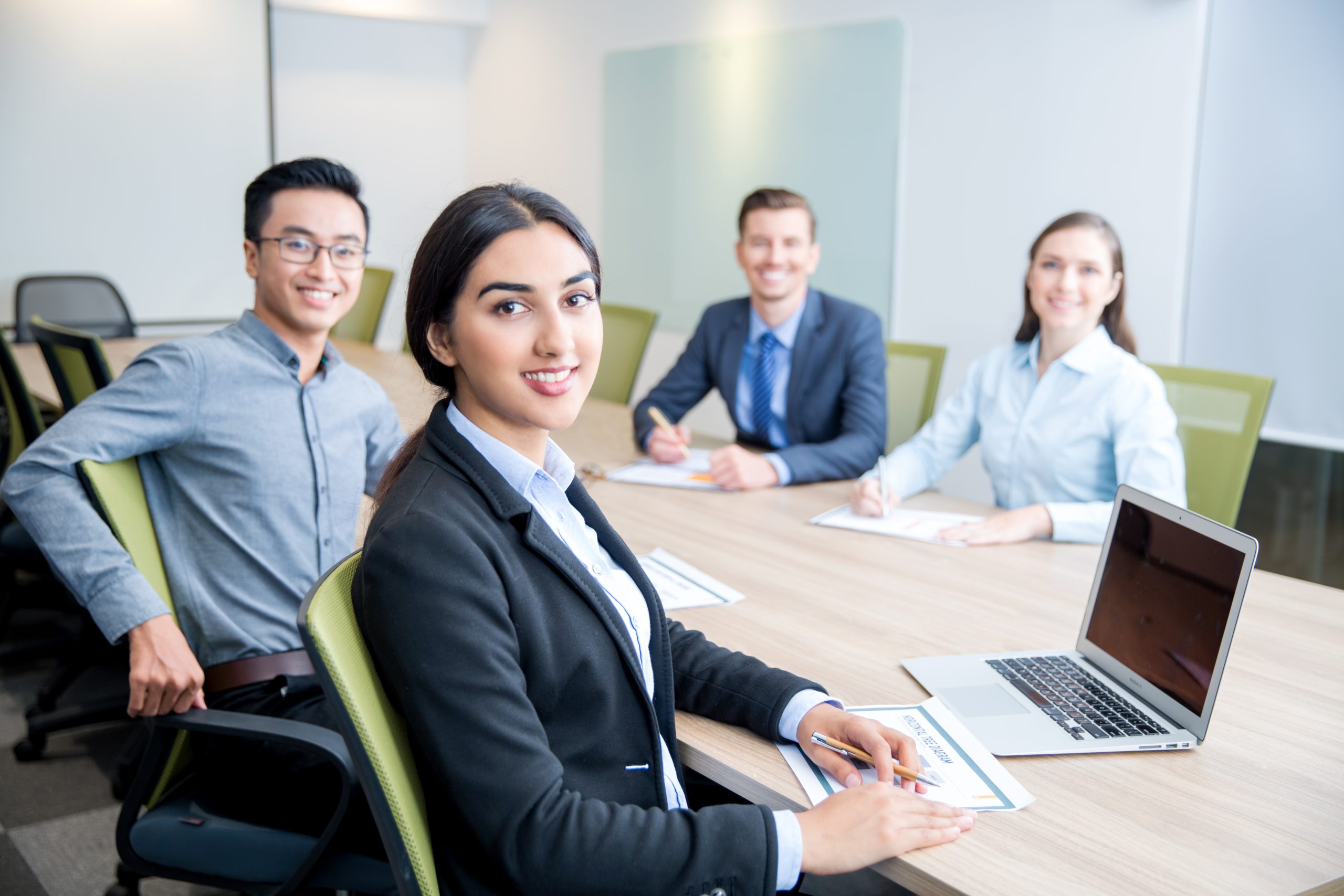 Smiling businesswoman collaborating with colleagues in a professional office.